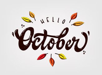 cute hand lettering 'Hello October' quote decorated with sketched leaves. © Натали Осипова