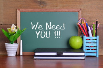 Green school chalkboard with written sentence 'We Need You'