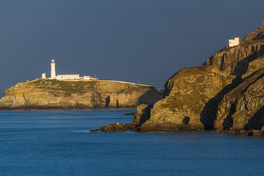 Lighthouse with castellated tower in morning light.