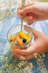  mango and chia seed pudding in a glass tumbler stands on a blue napkin