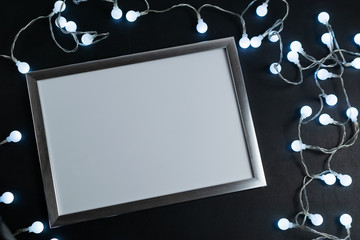 Empty mockup white frame on a blackboard with led glowing lights
