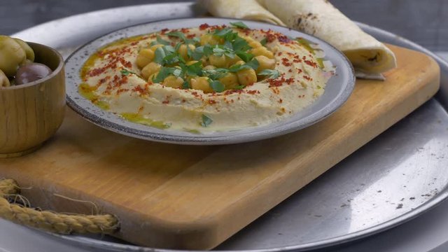 Dish with hummus, pita and olivs.