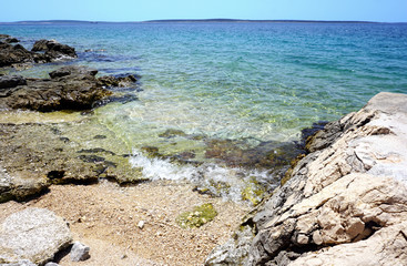 Fototapeta na wymiar Wild sea coast beautiful blue lagoon with pebble beach