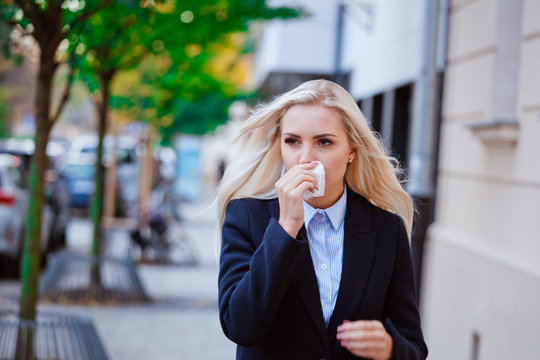Businesswoman blowing nose outdoor