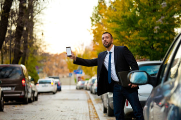 Young businessman waiting for uber or taxi in the city