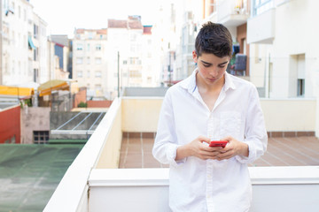 Fototapeta premium fashionable young teen on the terrace with mobile phone