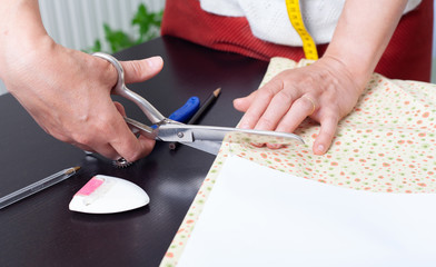 Obraz premium Dressmaker at work, building patterns, hands, modeling, measuring, sewing machine