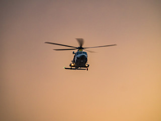 Naklejka na ściany i meble Helicopter in the sunset over the Caribbean island of Curacao