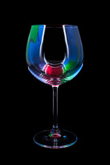 Party wine glass lit by red, green, blue nightclub lights, nightlife and entertainment industry, object isolated on black background 