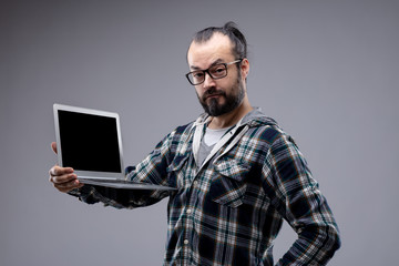 Quizzical man holding a laptop on display