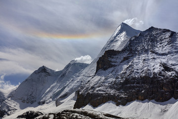 Yangmaiyong, holy snow mountain in Daocheng Yading Nature Reserve - Garze, Kham Tibetan Pilgrimage region of Sichuan Province China. Rainbow in the sky above the summit of Jampayang