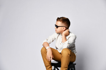 Cute stylish boy sitting on chair
