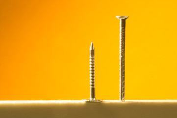 Metal nails isolated on yellow background. working tools