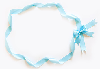 Frame made of blue satin ribbon with a bow. White background.