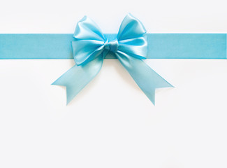 Blue wide satin ribbon with a bow. White background.