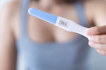 Closeup woman hand holding pregnancy test with happy moment, health care concept, selective focus