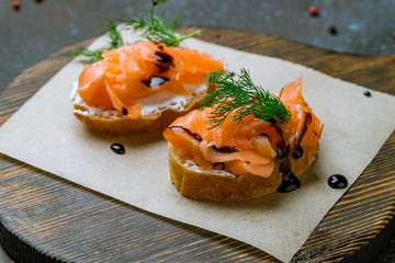 Bruschetta with salmon and cheese on blue concrete table