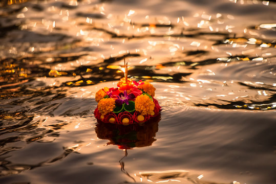 Paper lotus flower with candle floating on a river at night in Loy krathong festival, traditional Siamese new year festival celebrated in Thailand.