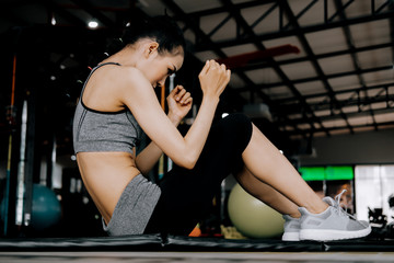 Fototapeta na wymiar sport woman at fitness gym club doing sit up exercise for body and showing muscle bodybuilding, fitness concept, sport concept