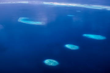 Fototapeta na wymiar Dieses einzigartige Bild zeigt die Malediven, die von einem Flugzeug von oben fotografiert werden. Sie können die Atolle im Meer gut sehen.