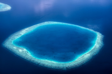 Dieses einzigartige Bild zeigt die Malediven, die von einem Flugzeug von oben fotografiert werden. Sie können die Atolle im Meer gut sehen. - obrazy, fototapety, plakaty
