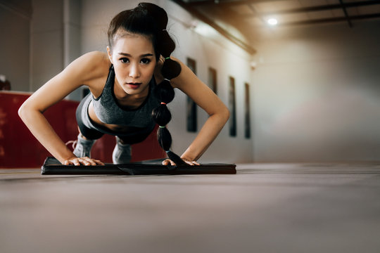 sport woman at fitness gym club doing push up exercise for body and showing muscle bodybuilding, fitness concept, sport concept
