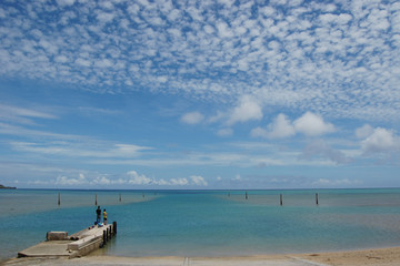 Obraz premium 田舎の港の桟橋で釣りをする親子