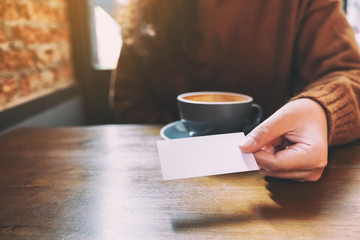 A woman holding and giving a blank empty business card to someone