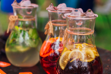 Cold lemonade with ice, mint and fruits. Lemon and green mint leaves in a jar.