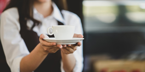 Beautiful young waitress and a cup of coffee