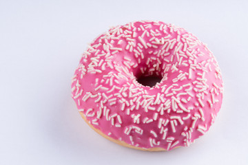 Pink donut on white background, close up macro