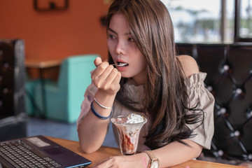 Beautiful girl sitting to eat ice cream in a restaurant