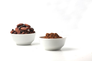 two bowls with cacao beans and cacao powder isolated on white background