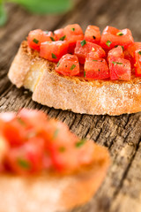 Fresh homemade tomato and basil bruschetta traditional Italian antipasto (Selective Focus, Focus on the first tomato pieces on the bread in the back)