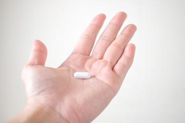 White medicine on Asian hands on a white background.
