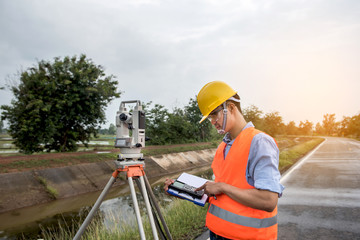 Young man engineer is using Surveyor equipment tacheometer or theodolite worker on the road.