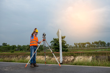 Young man engineer is using Surveyor equipment tacheometer or theodolite worker on the road.