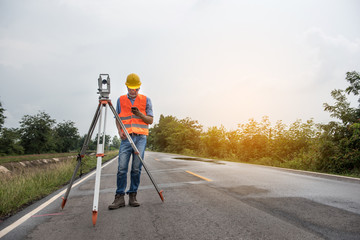 Young man engineer is using Surveyor equipment tacheometer or theodolite worker on the road.