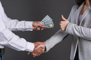 Close up photo of man hands giving money to a woman. Succesfull deal between partners. ..money...