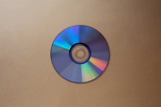 cd compact disc on a dark beige background top view  with copy space  