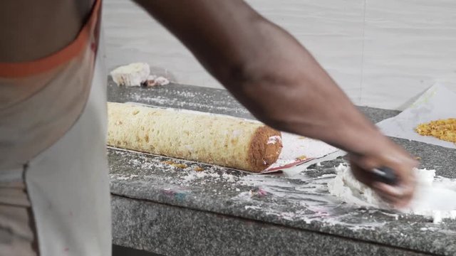 Man is in a kitchan and making a delicious meal with dough and some kind of sauce