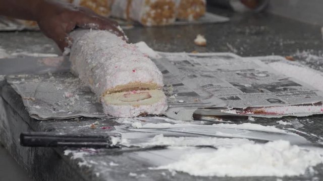 The process of cutting a big portion of jam roly-poly into smaller pieces
