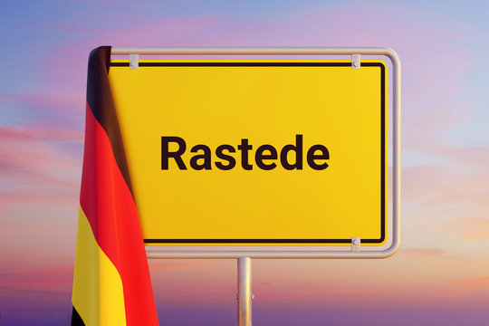 Rastede. Gelbes Schild/Ortsschild. Flagge von Deutschland h&auml;ngt dar&uuml;ber. Himmel mit Sonnenuntergang oder Sonnenaufgang
