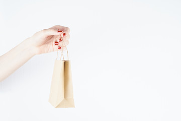 woman holding paper bag on white background, person with red nail polish, mockup design, copy space