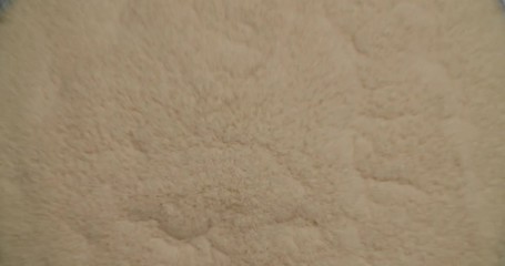 Sand-like substance bouncing off of vibrating surface forming cymatic patterns, then dispersing again. Granular particles forming amazing shapes on vibrating table.