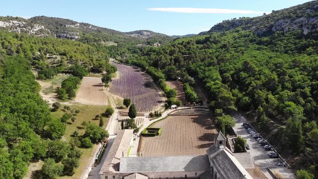 A drone moving above Senanque abbay revealing the structure and the lavanda fields