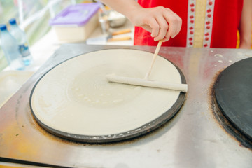 Crepe pancakes are handmade crepes on a hot metal grill. Outdoor summer festival