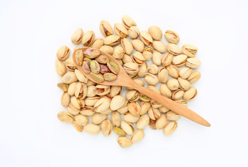 Pistachio nuts isolated on white background with wooden spoon. Top view.