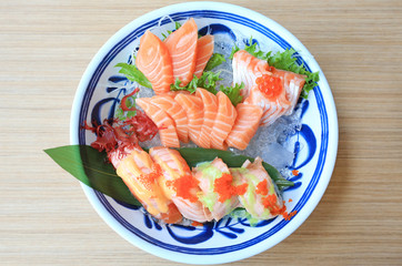 Sashimi sushi set served on ice against wooden table. Japanese food.