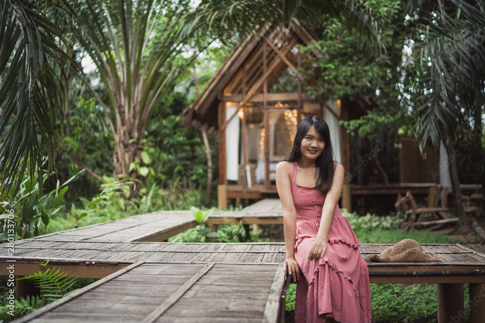 Wall mural young asian woman relax in forest, beautiful female happy using relax time in nature. lifestyle wome